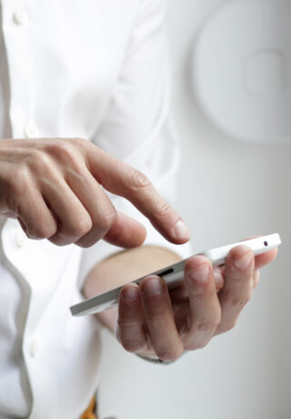 Person in white shirt pressing mobile phone screen