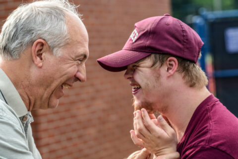 Two men facing each other smiling